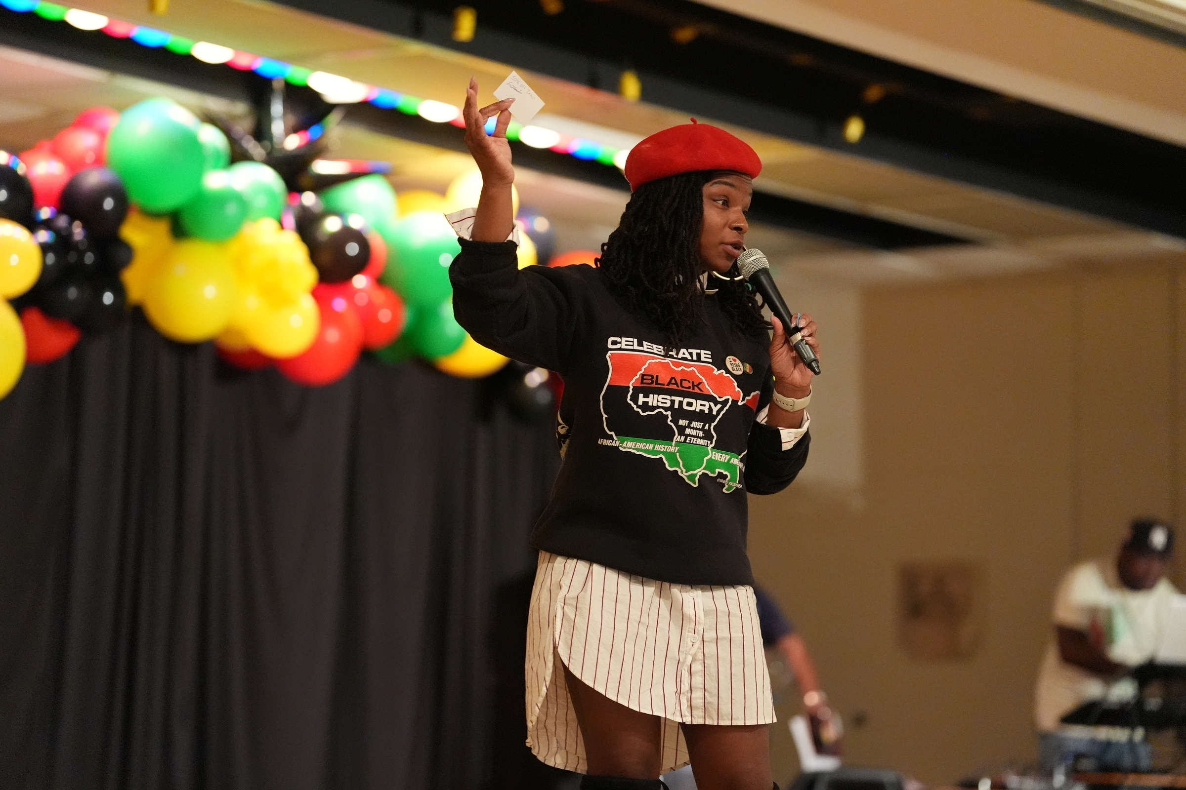Speaker addressing an audience on stage during a Black Heritage festival