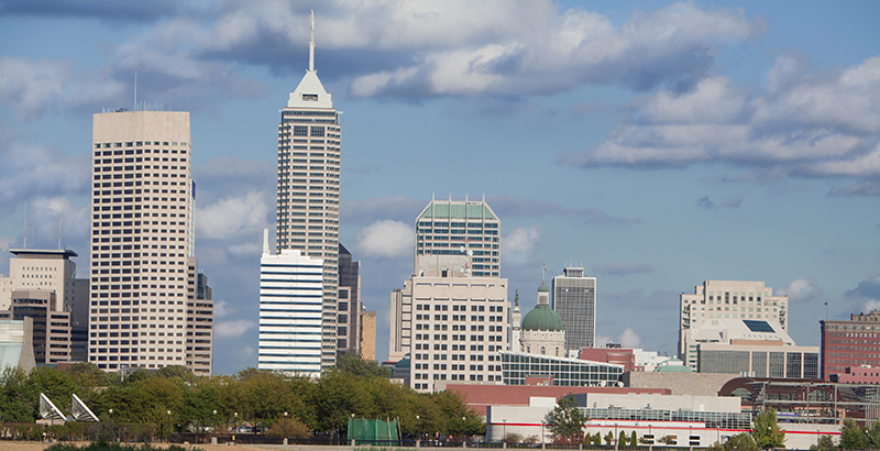 Downtown Indianapolis skyline under a partly cloudy sky.