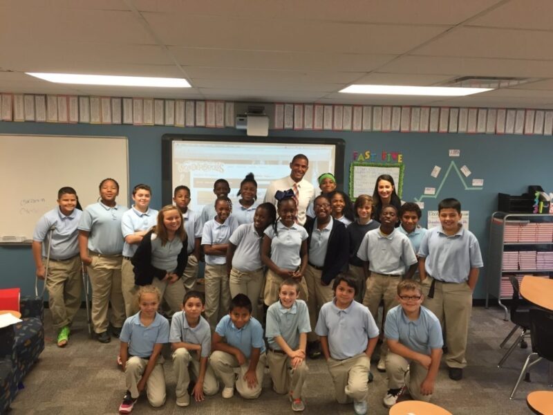 Paramount students and educators pose together for a group photo in a classroom.