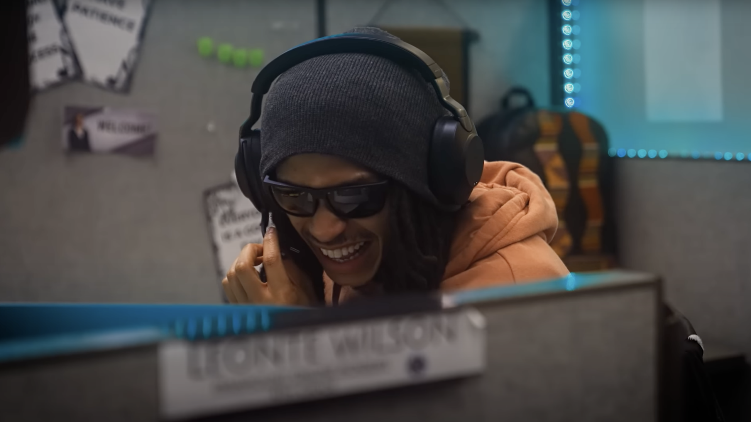Student wearing headphones and virtual reality glasses smiles during an immersive learning activity.