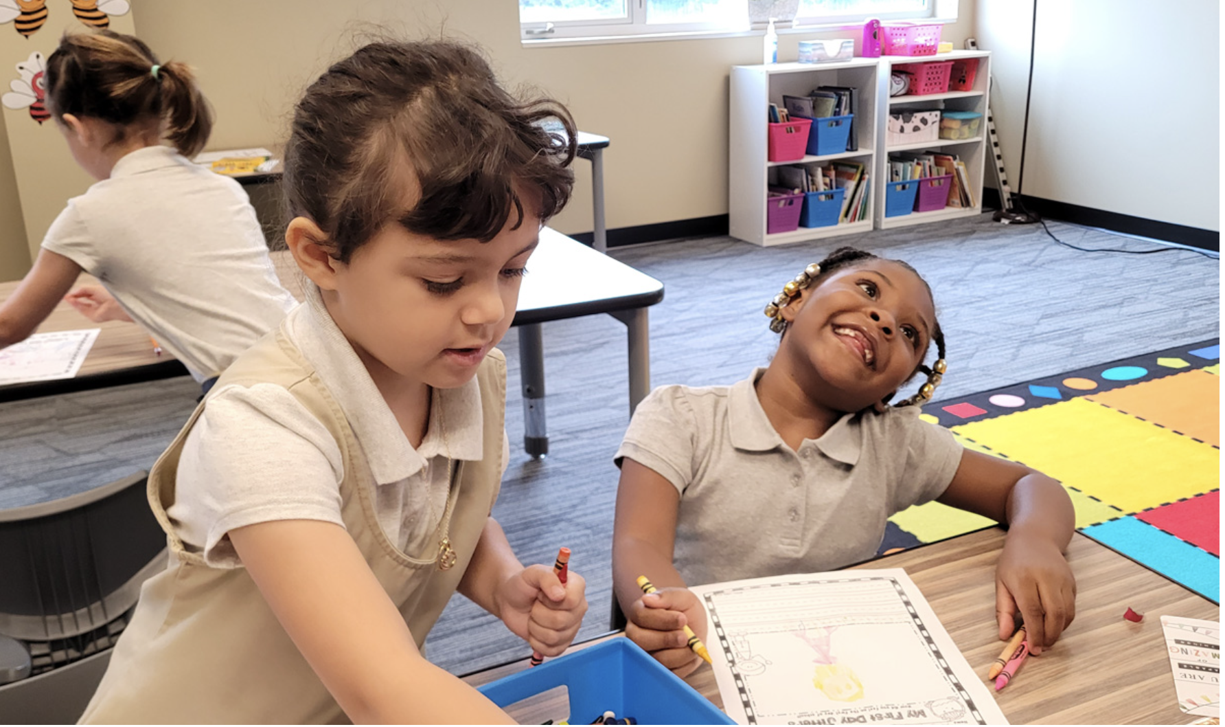 Young students work with crayons on a classroom activity together.