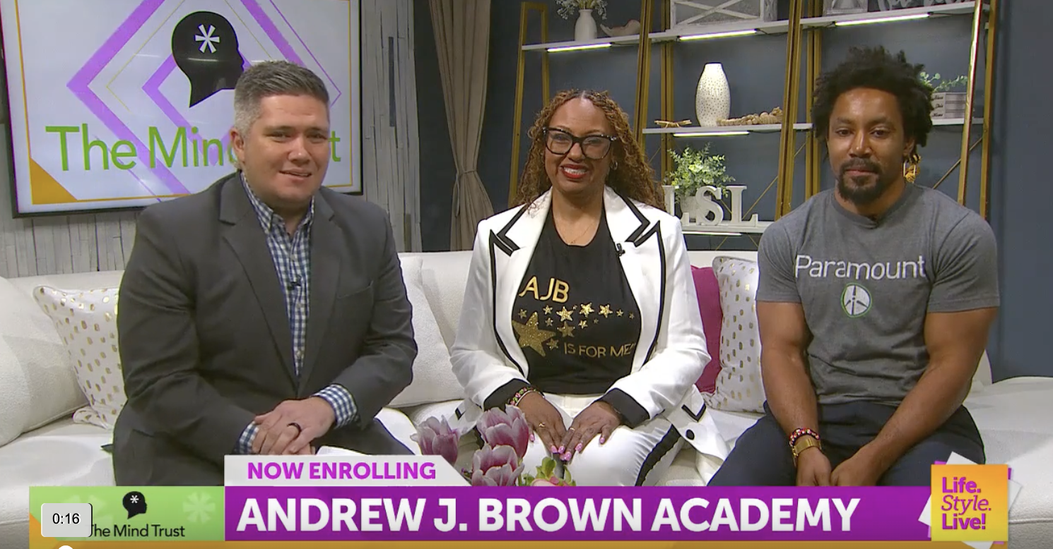 Andrew J. Brown Academy representatives discuss enrollment during an in-studio television interview.