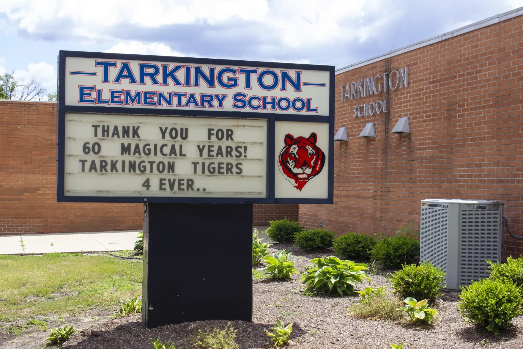Tarkington Elementary School sign thanking the community for 60 years, outside the school building.