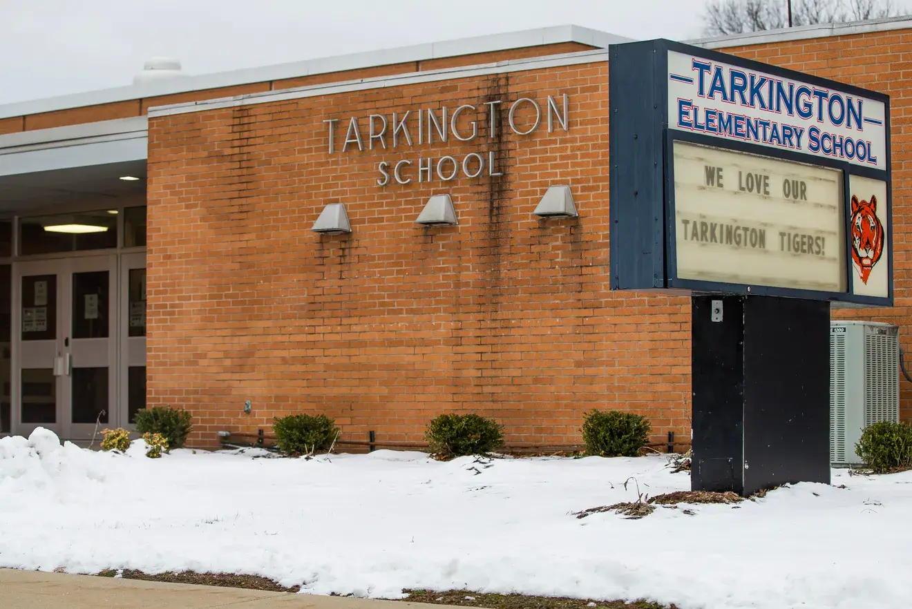 Snow-covered exterior of the Tarkington School building with the school marquee in front.