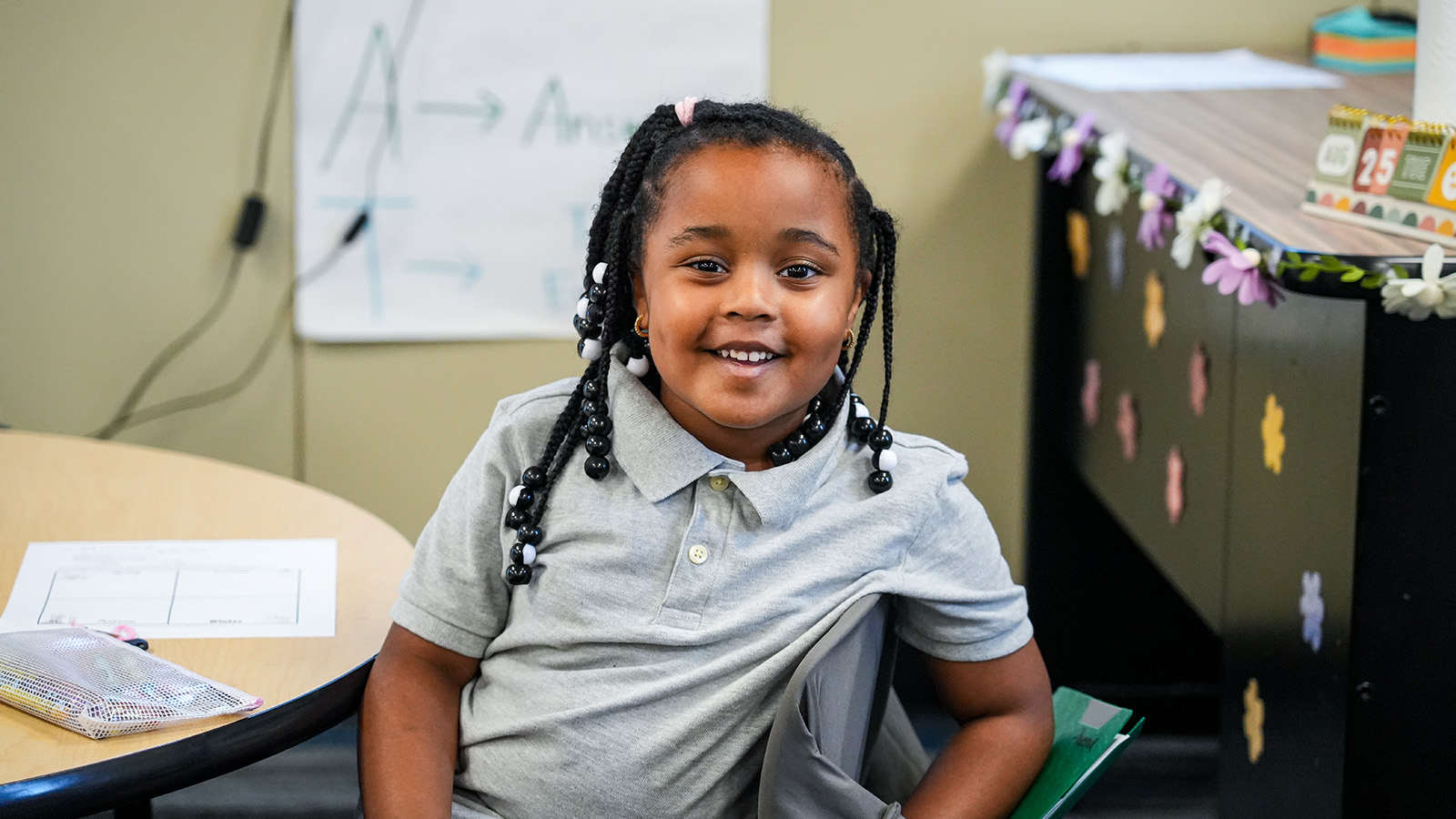 Smiling Paramount Brookside student sitting at a classroom table