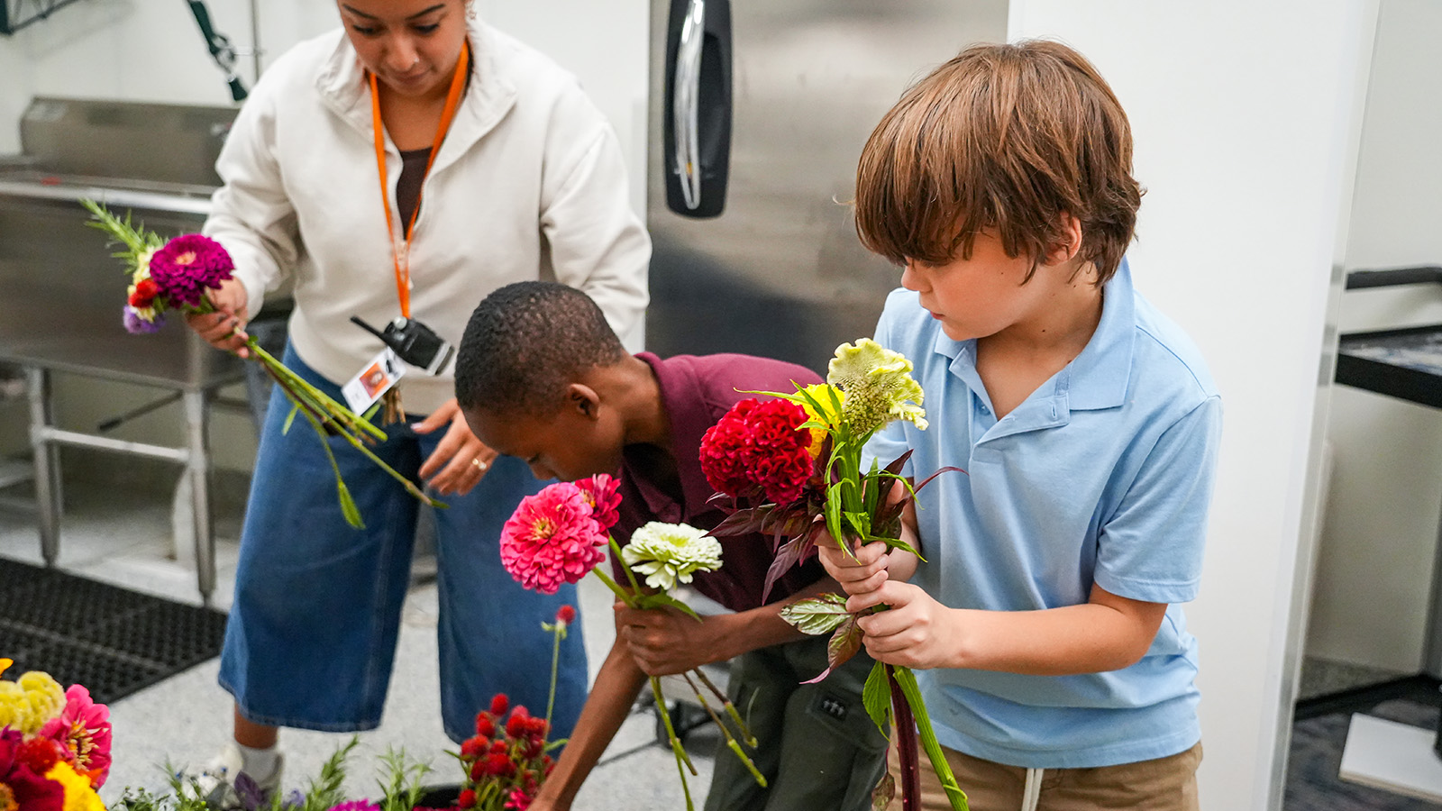 Paramount students arranging colorful flowers with guidance from a staff member