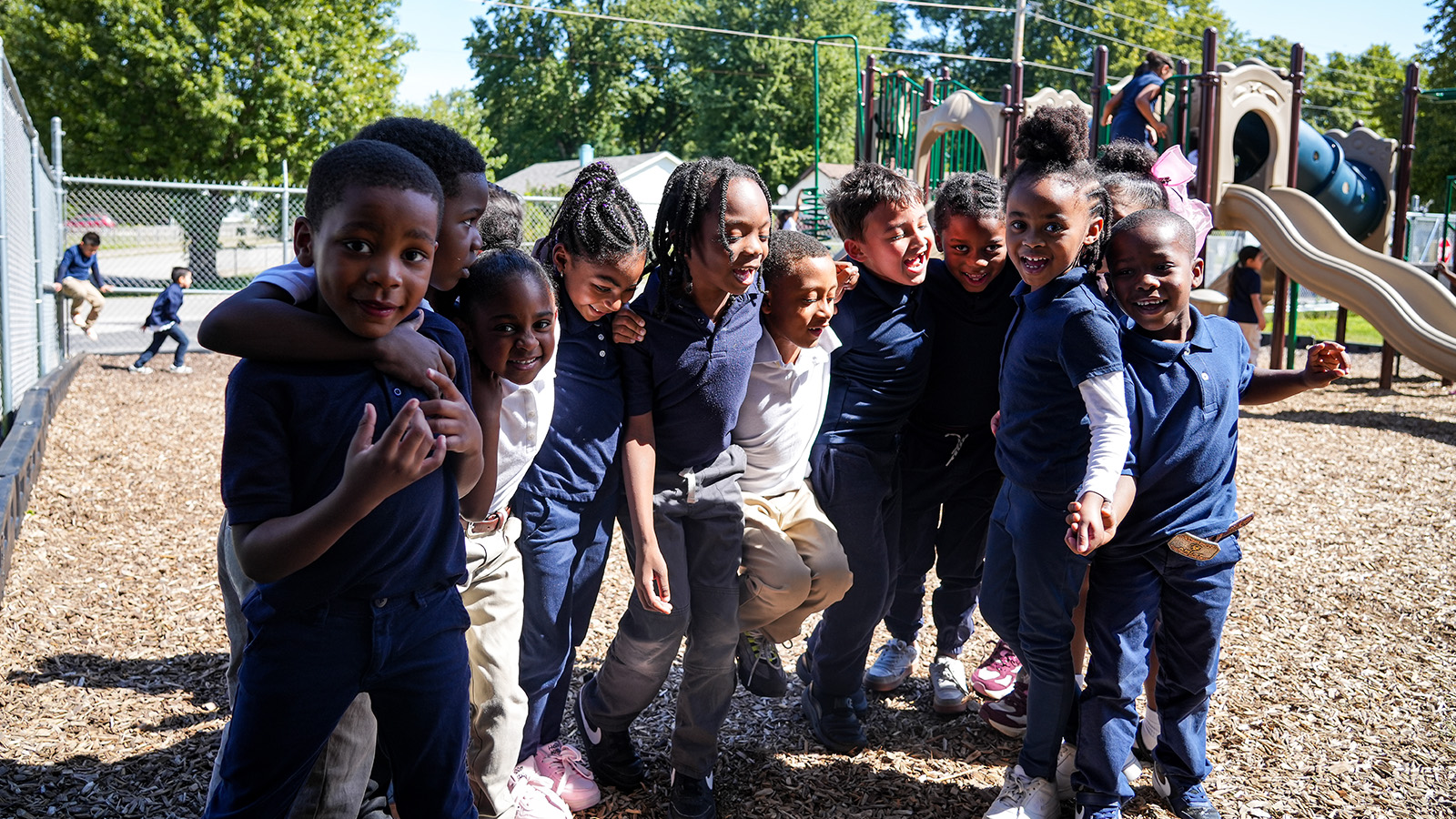 Andrew J. Brown Academy students smiling and posing together on the school playground during recess