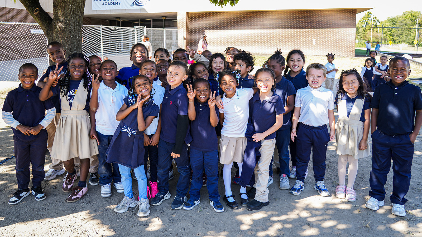 ajb-features-hero-updated Andrew J. Brown Academy students smiling and posing together for a group photo outside their school building in Indianapolis