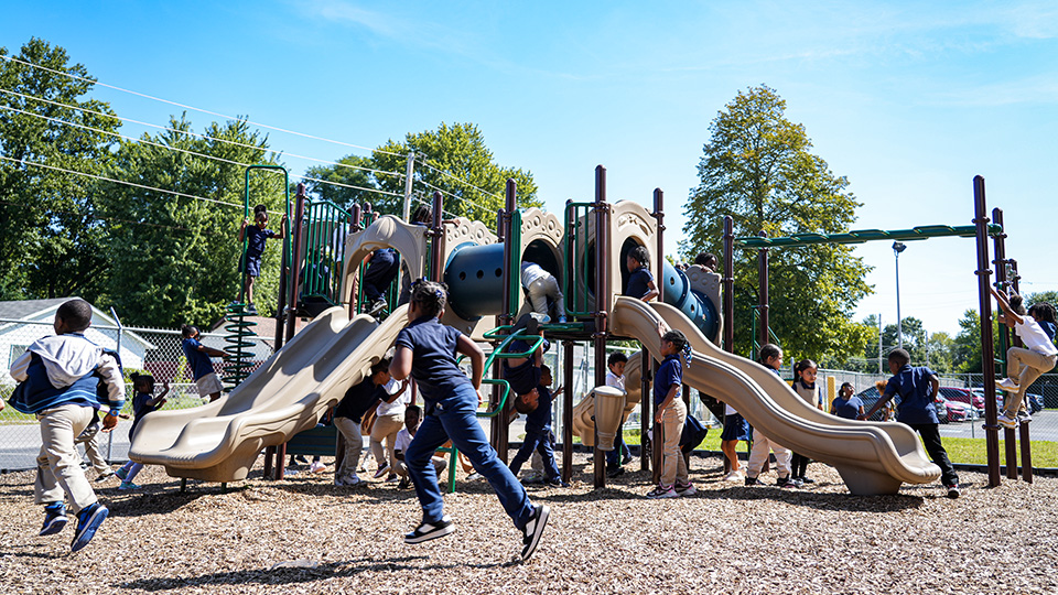 Andrew J. Brown Academy students running, climbing, and playing together on the school playground during outdoor recess