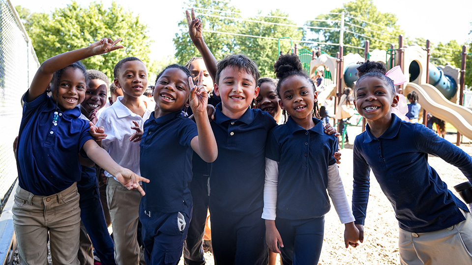 Andrew J. Brown Academy students smiling and posing together on the school playground during recess