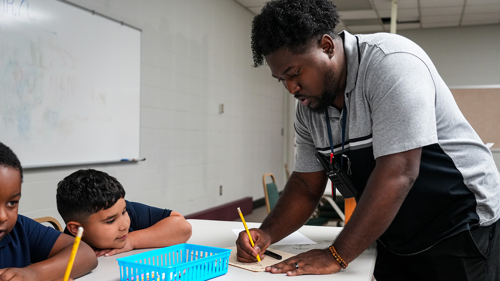 Andrew J. Brown Academy teacher providing hands-on instruction to students during a classroom assignment