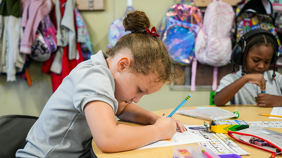 Paramount Brookside student completing a writing assignment at a classroom table