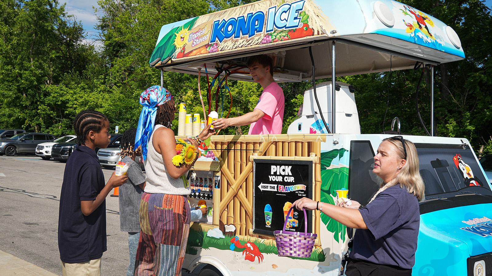 Paramount Online Academy students and families enjoying shaved ice from a Kona Ice truck during an outdoor school event