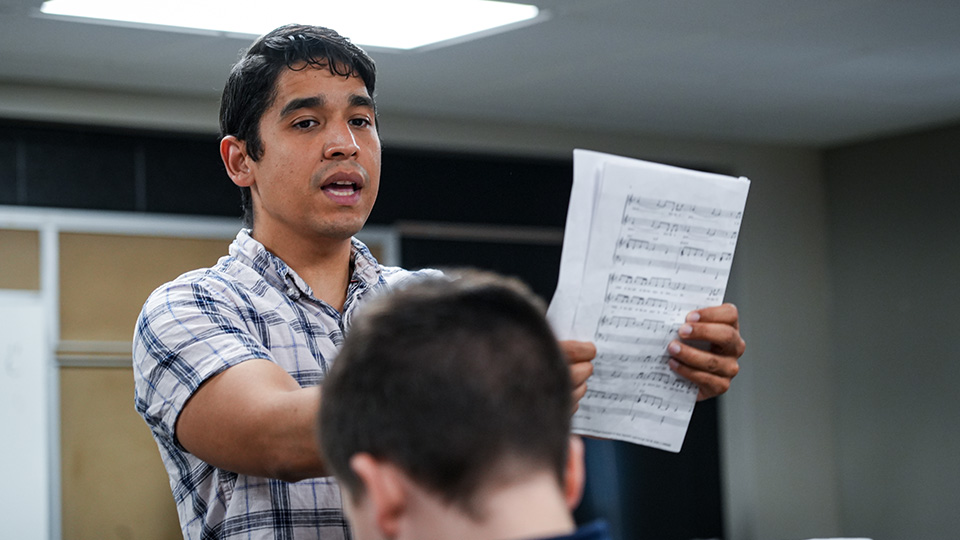Paramount teacher leading a music lesson while holding sheet music