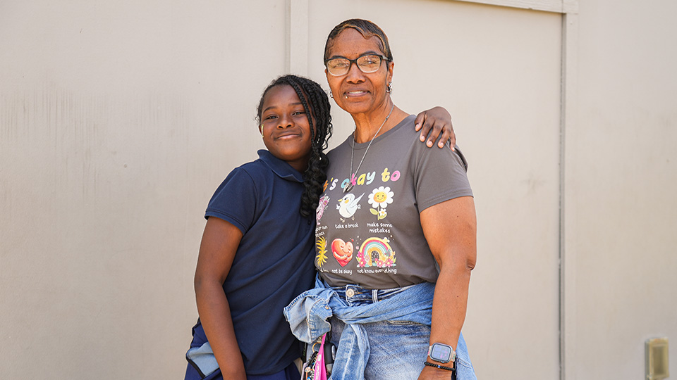 Paramount staff member posing with a student outside the school