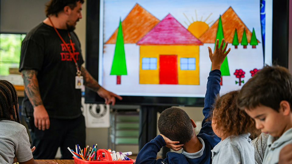 cottage-home-features-2 Paramount Cottage Home teacher leading an interactive classroom lesson as a student raises their hand