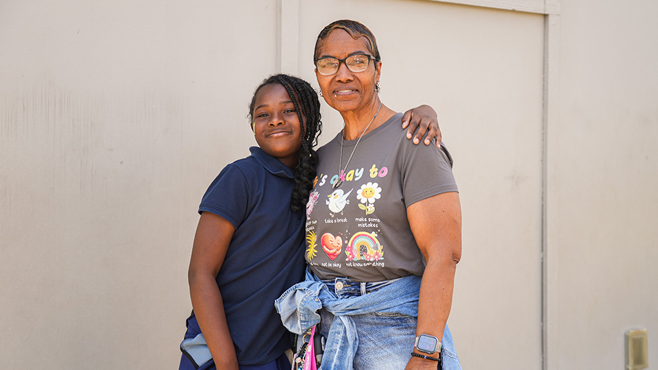 cottage-home-features-3 Paramount Cottage Home student posing with a smiling adult outside the school