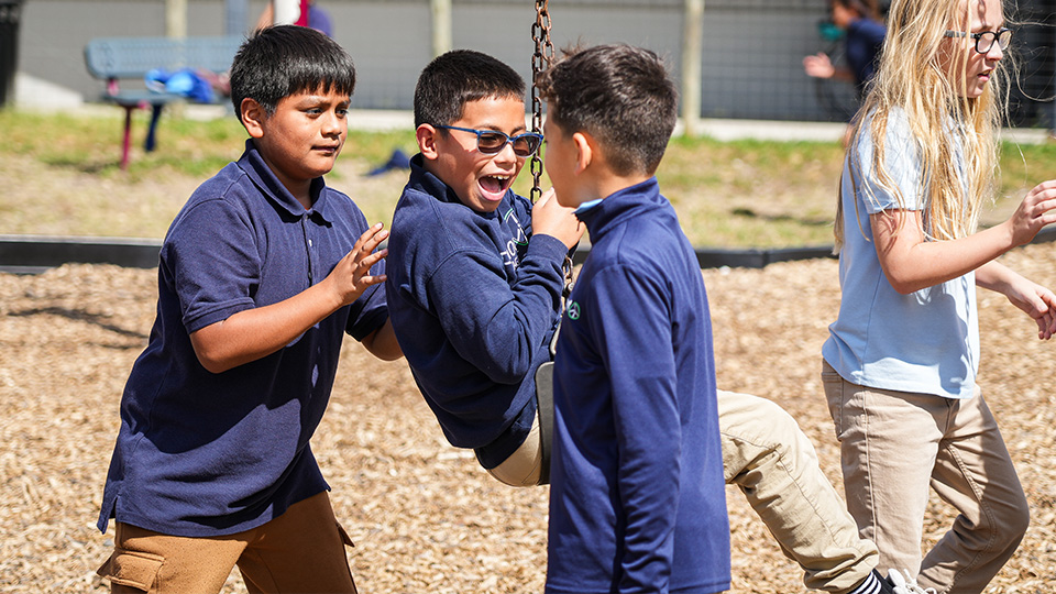 cottage-home-home-4-3 Paramount Cottage Home students playing together on the school playground swings