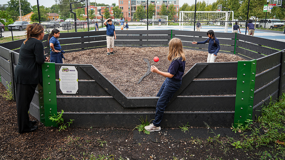 Paramount Englewood students playing a ball game in an enclosed outdoor recreation area