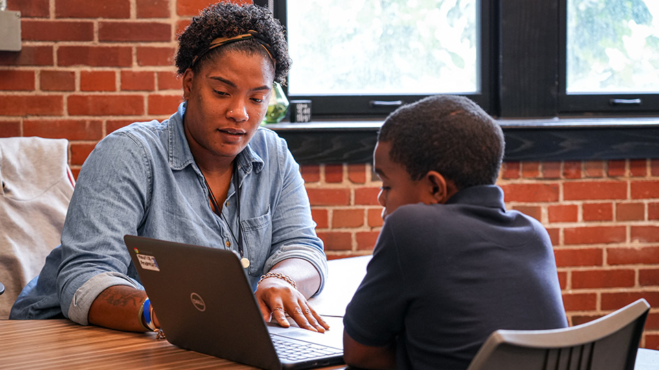 Paramount Englewood teacher providing one-on-one instruction to a student using a laptop