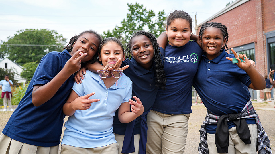 family-support-services-1 Five Paramount Cottage Home students smiling and posing together outside their school
