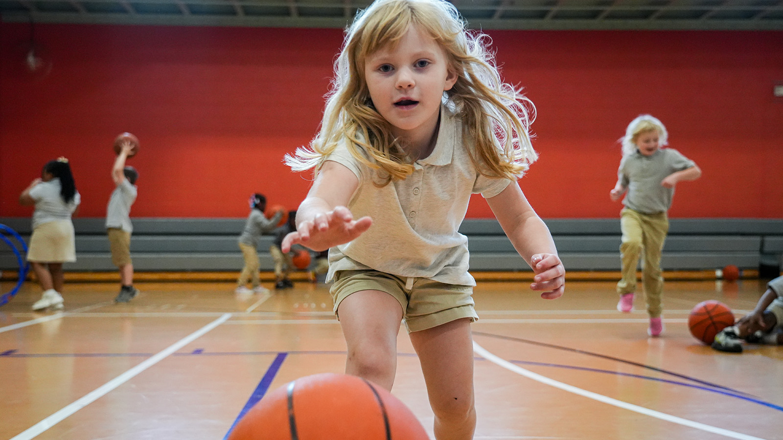 family-support-services-hero Paramount student reaching for a basketball during a physical education activity in the school gym