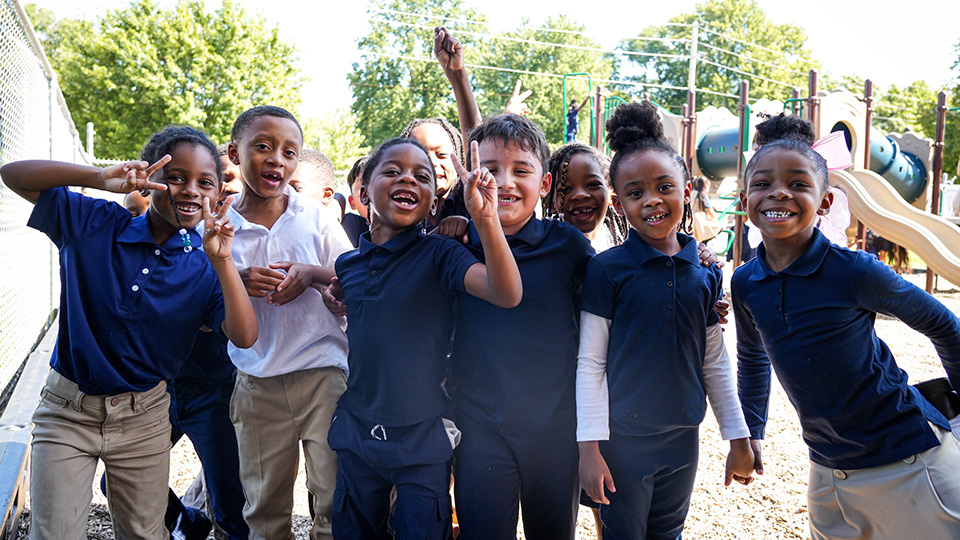 Group of smiling Paramount students posing together on the school playground