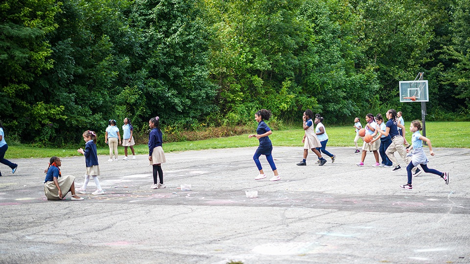 gisa-features-3 Girls IN STEM Academy students running and playing basketball on an outdoor school court