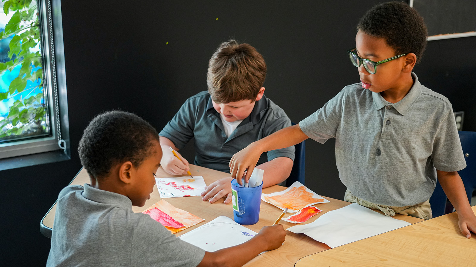 lafayette-contact-hero Paramount Lafayette students collaborating on a colorful painting activity at a classroom table