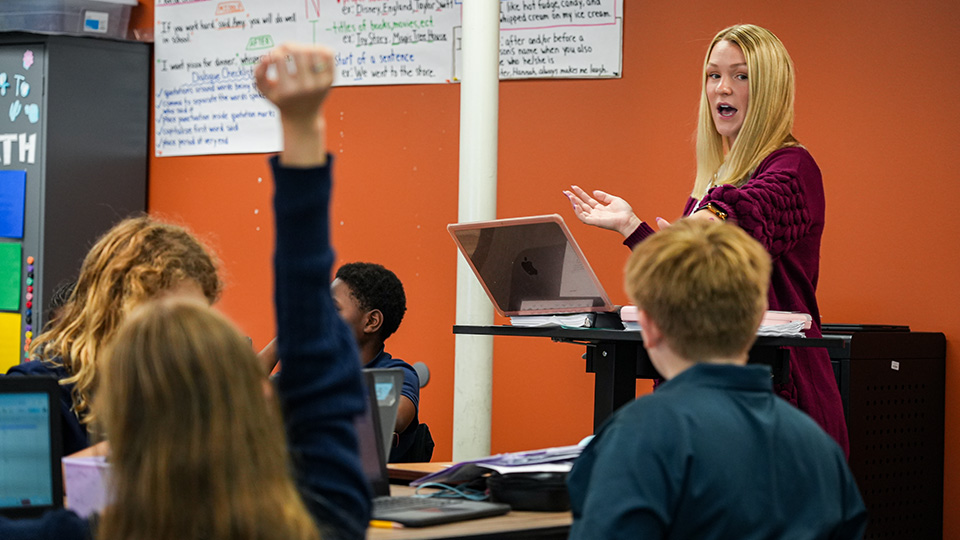 Paramount Lafayette teacher leading an interactive classroom lesson as a student raises their hand to participate