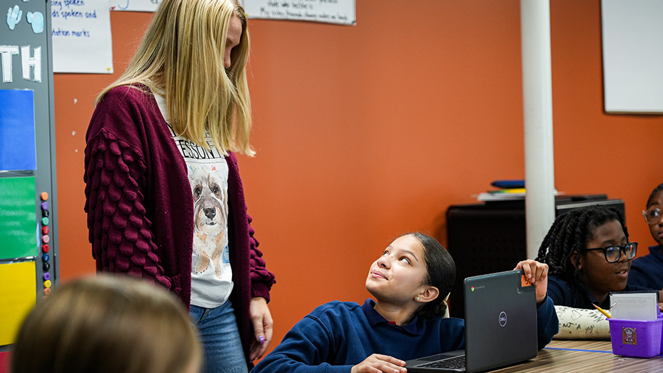 Paramount Lafayette teacher assisting a student with her laptop during a classroom lesson