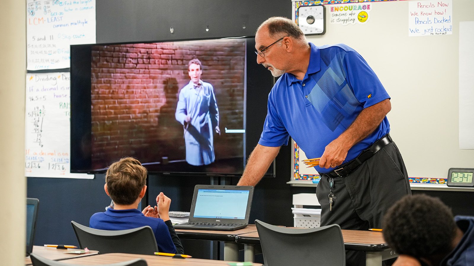 Paramount Lafayette teacher assisting a student with a laptop during a classroom lesson