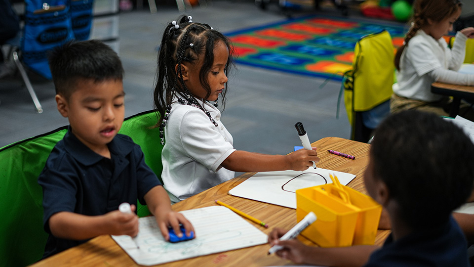 mission-and-results-1 Young Paramount students practicing writing and drawing on individual whiteboards during a classroom activity