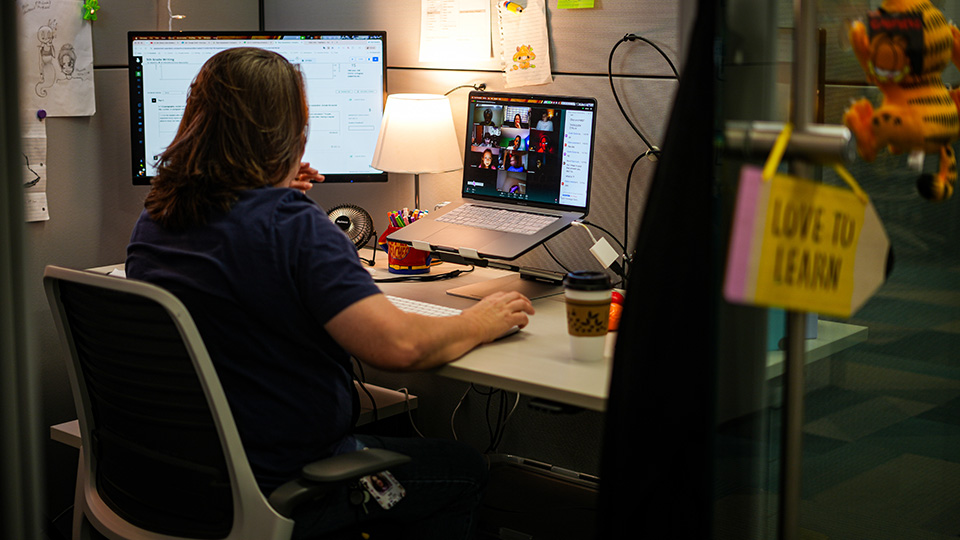 Paramount Online Academy teacher working at her desk while leading a virtual classroom lesson with students through video conferencing
