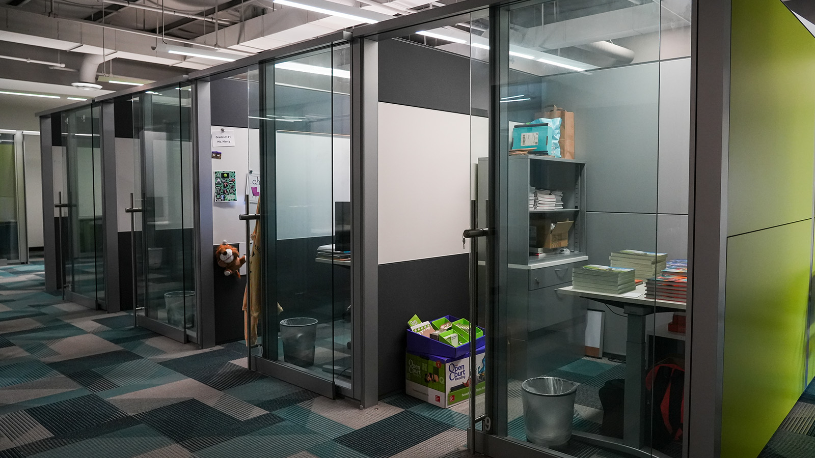 online-academy-contact-hero Paramount Online Academy offices featuring glass-enclosed workspaces and educational materials for teachers and staff