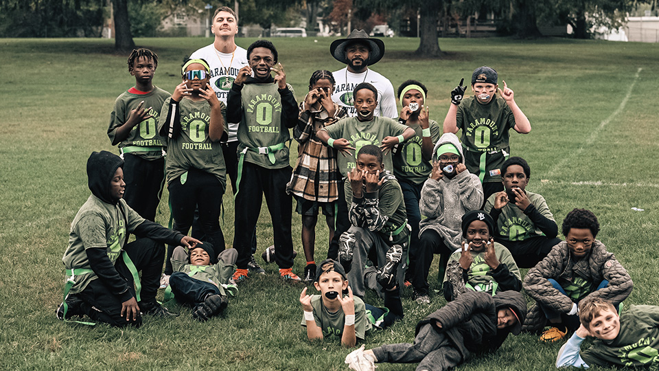 Paramount Schools of Excellence football team posing together on the field, highlighting athletic opportunities available to Paramount Online Academy students through other Paramount schools.