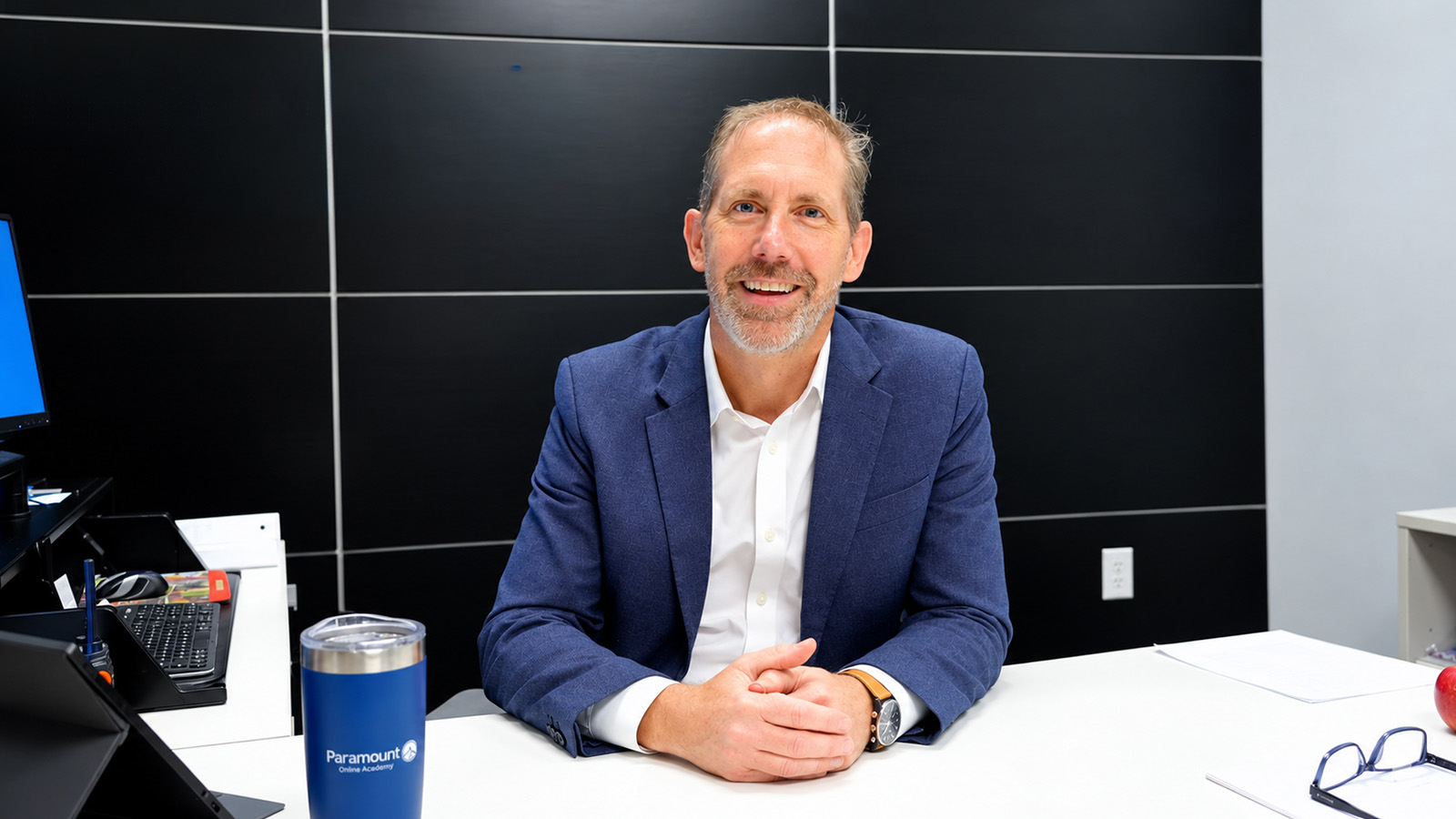 Paramount Online Academy Principal Anthony Brose smiling for a professional portrait while seated at his desk in his office