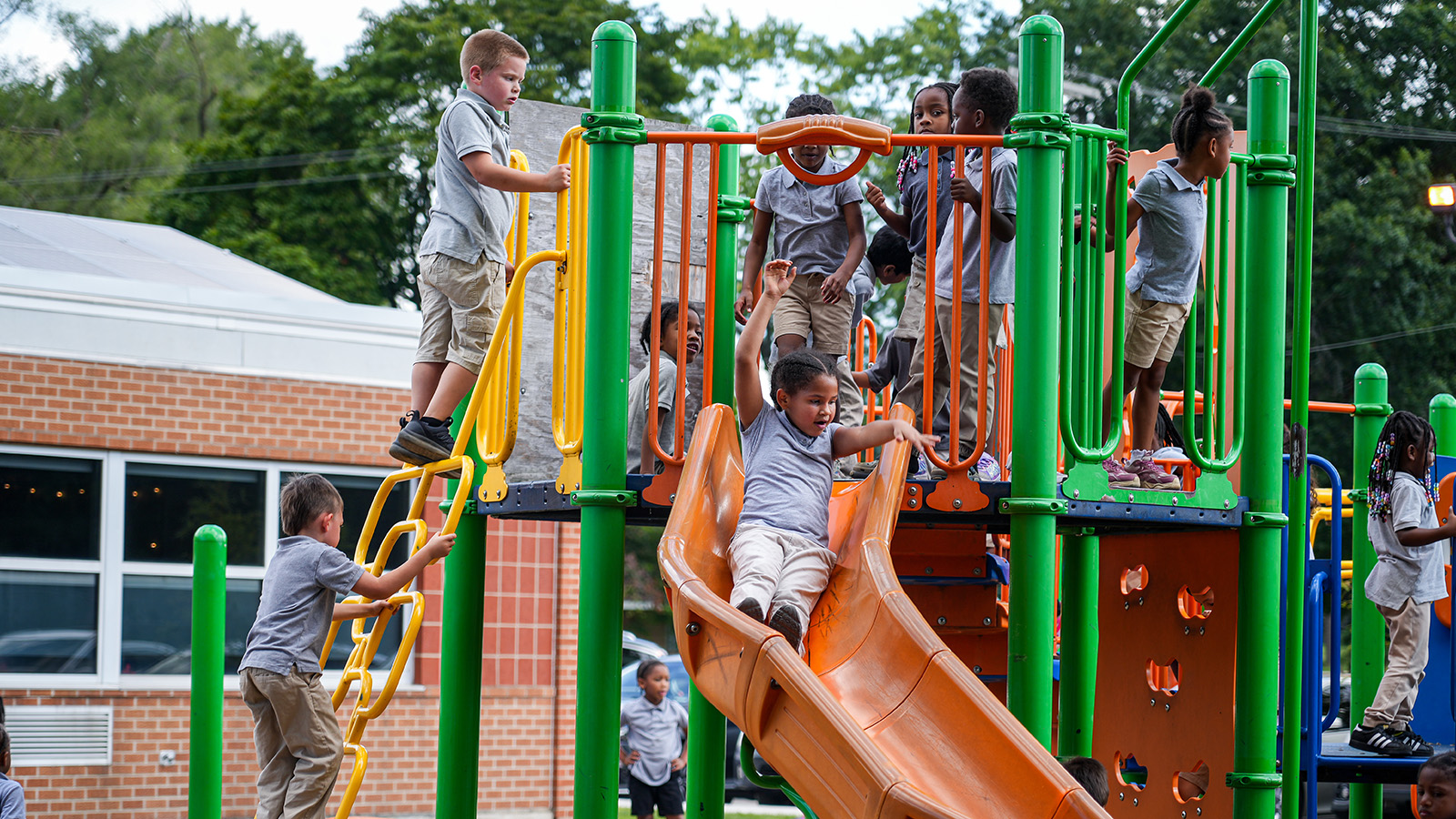 south-bend-apply-hero Paramount South Bend students climbing, sliding, and playing together on colorful playground equipment during outdoor recess