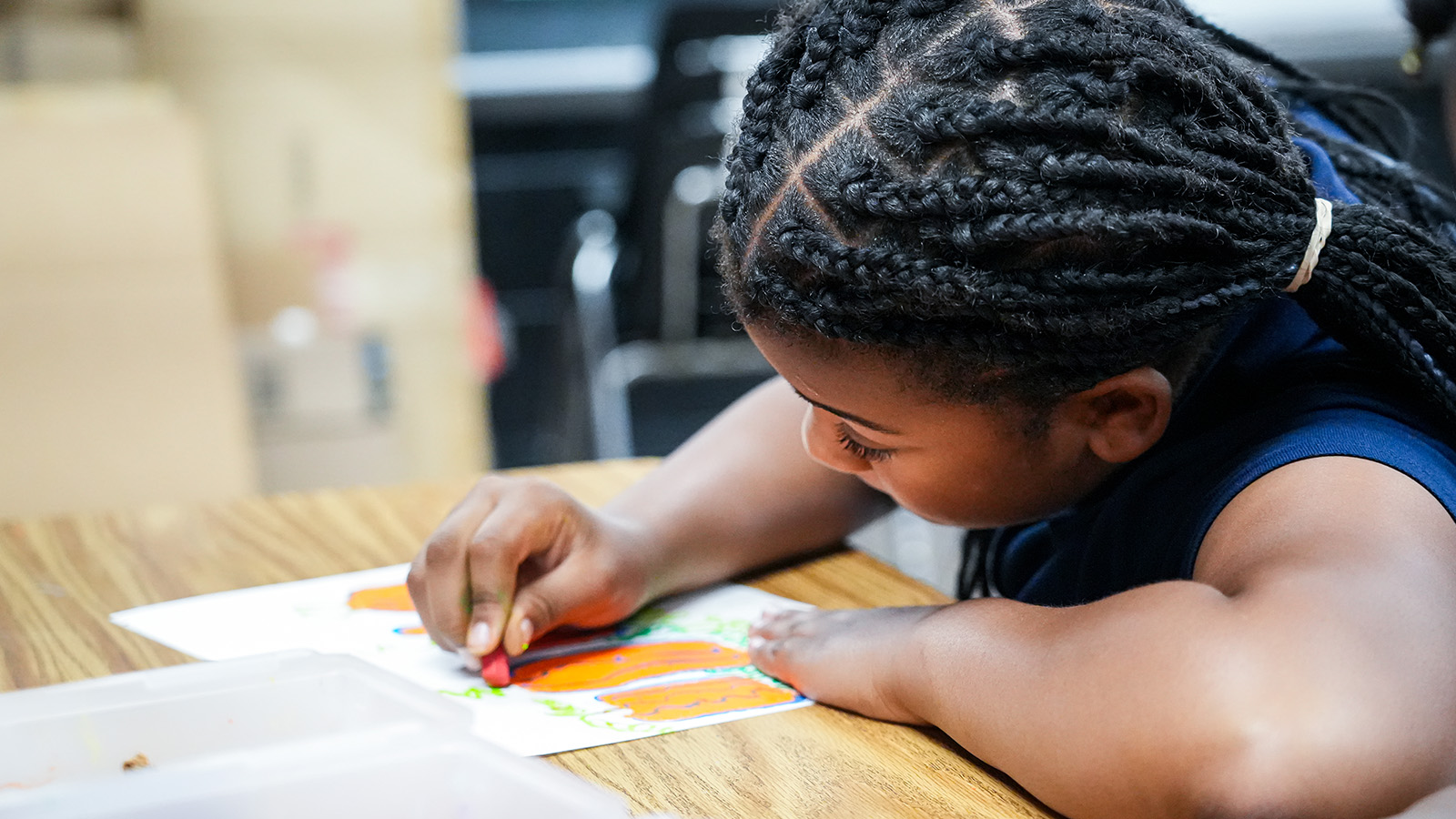 south-bend-contact-hero Paramount South Bend student concentrating on a colorful drawing during a classroom art activity