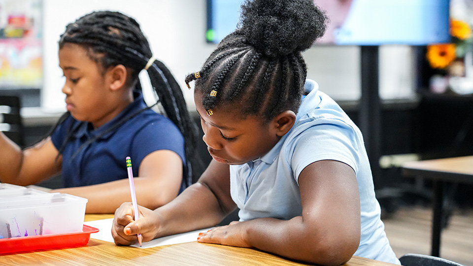 Paramount South Bend students concentrating on writing assignments at their classroom desks