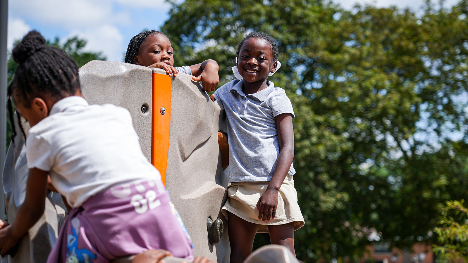south-bend-parent-center-hero Paramount South Bend students smiling and climbing together on outdoor playground equipment during recess
