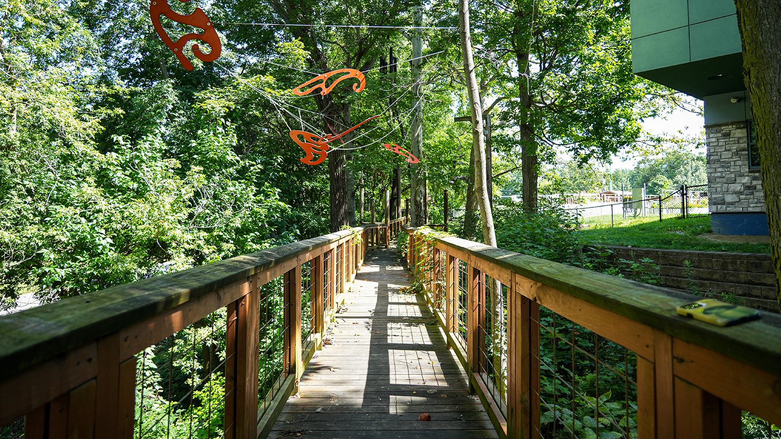 visit-hero Wooden nature walkway through the wooded outdoor learning area at Paramount Brookside